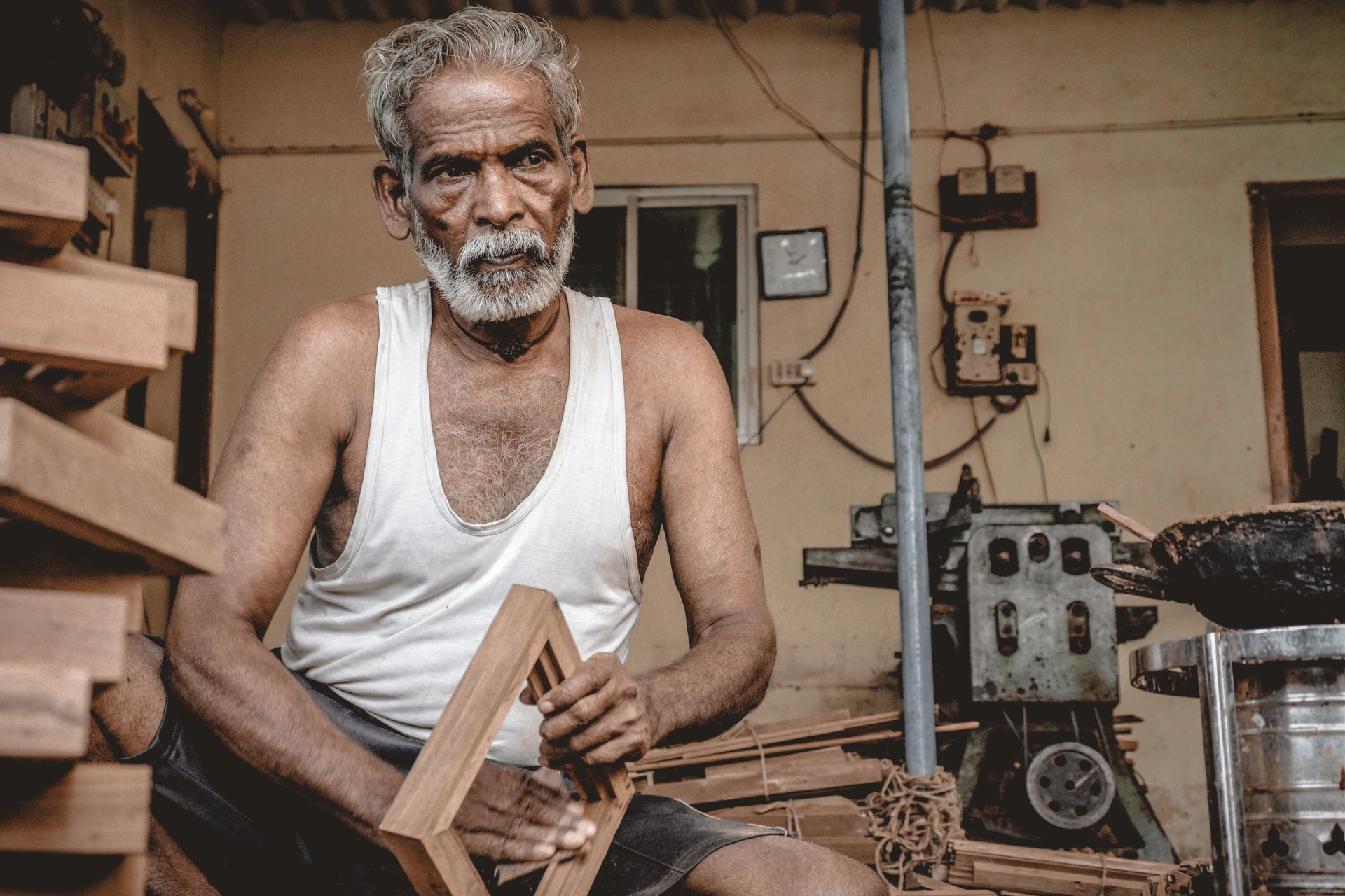 An experienced grey-haired carpenter in his workshop