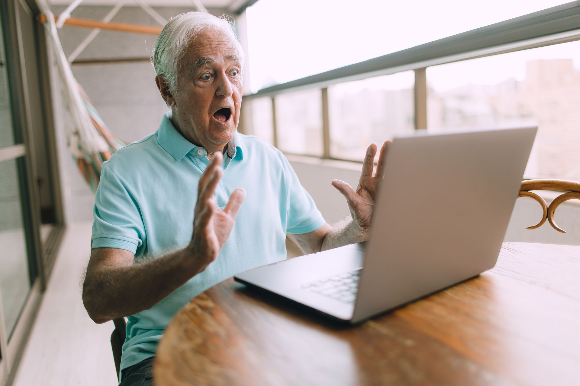 An older man reacting with surprise to his laptop screen